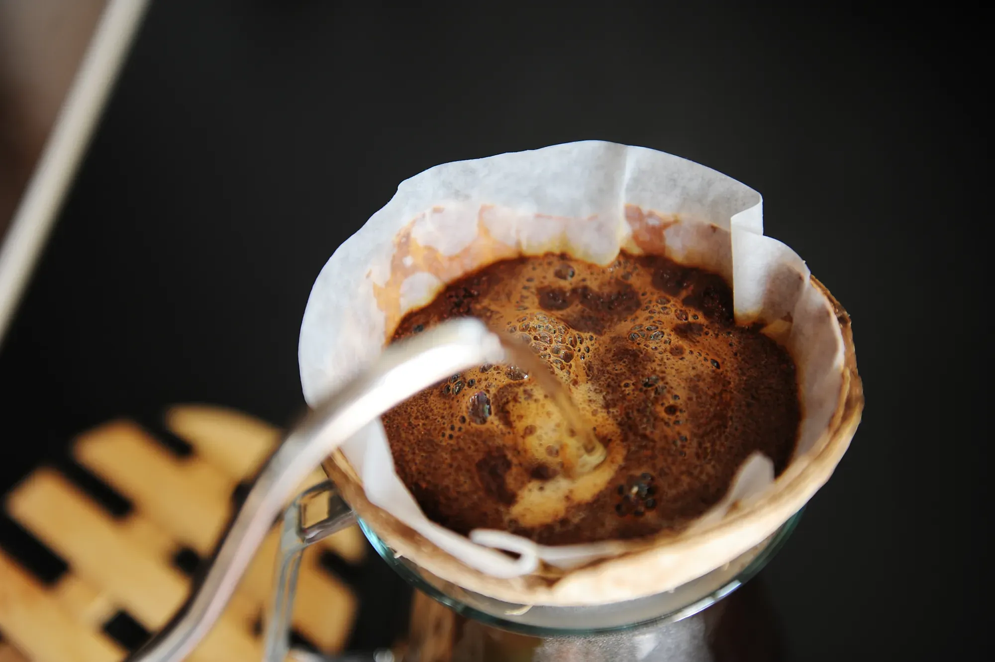Kaffee im Handfilter wird mit dem Schwanenhalskessel langsam aufgegossen.